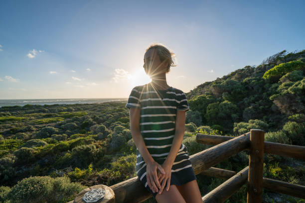istock Young woman watching sunset from wooden patio 682979652