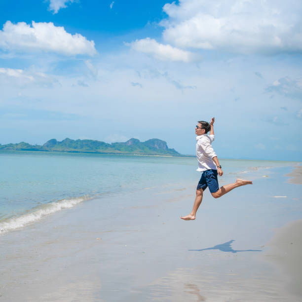 istock Relaxing Businessman using  laptop and smartphone on the beach 682982952