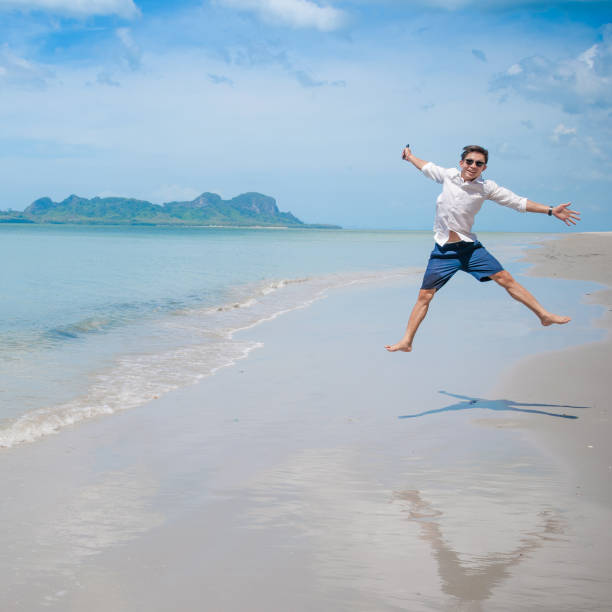 istock Relaxing Businessman using  laptop and smartphone on the beach 682983178