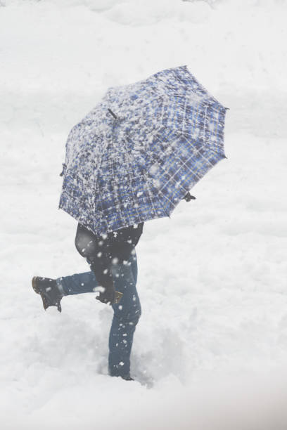 istock Lonely man with umbrella in the snowstorm 682985410