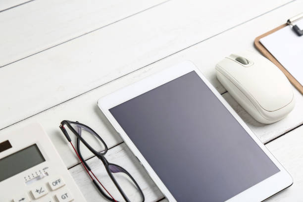istock glasses, calculator,coins and tablet on white neat desk 682986628