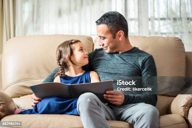 Little Girl And Father Reading Book Stock Photo - Download Image Now - Baby - Human Age, Baby Girls, Book