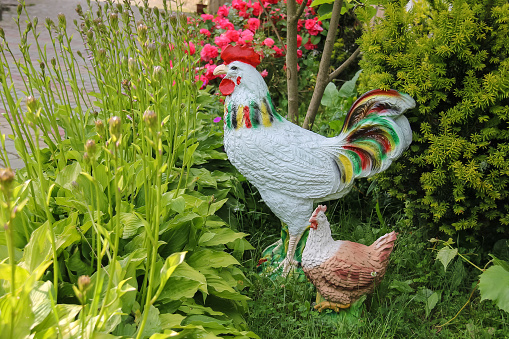 Decorative figures of rooster and chicken in the garden