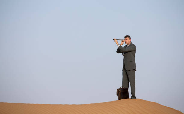 istock man in a suit in a desert with a spyglass 682996760