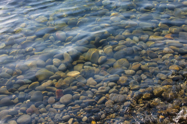 istock sea pebble beach with multicoloured stones, waves with foam 683002440