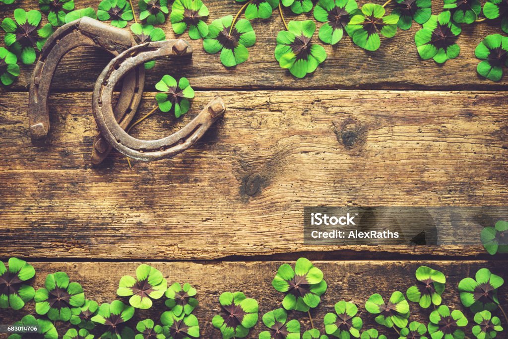 St. Patrick's day, lucky charms St. Patrick's day, lucky charms. Horseshoe and shamrock on wooden background Clover Stock Photo