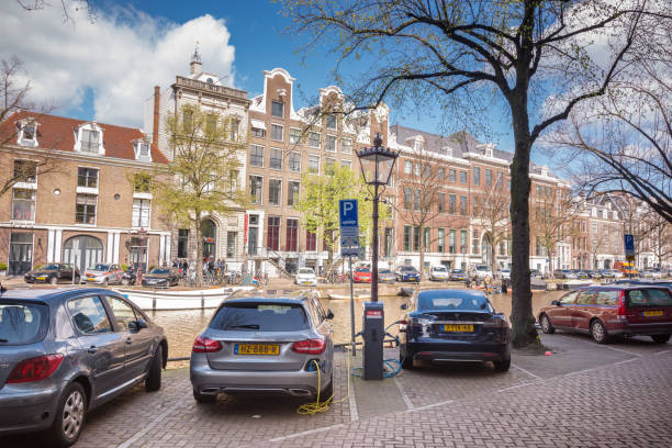 Voitures en stationnement électriques de charge le long des canaux d’Amsterdam, Pays-Bas - Photo