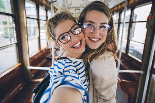 Sisters having fun while traveling with tramcar