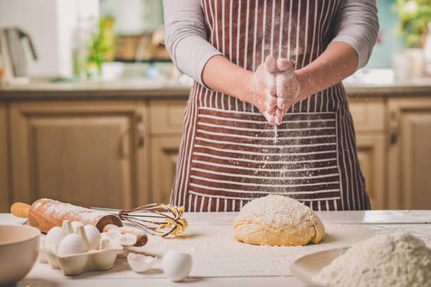 Woman slap his hands above dough closeup. Baker finishing his bakery, shake flour from his hands, free space for text stock photo