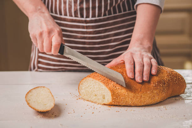 istock Woman cutting bread on wooden board. Bakehouse. Bread production 683038626