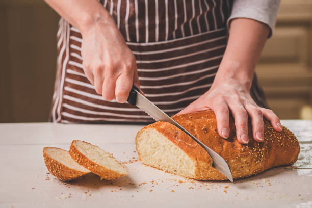 istock Woman cutting bread on wooden board. Bakehouse. Bread production 683038670