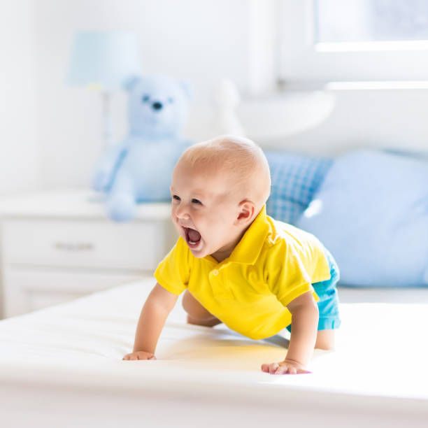 istock Baby boy playing on bed in sunny nursery 683041838