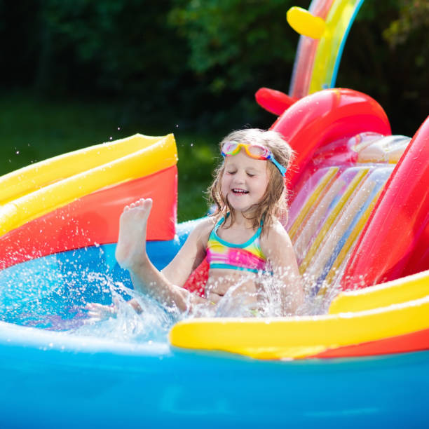 istock Child in garden swimming pool with slide 683042014