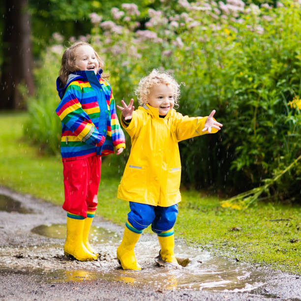 istock Kids play in rain and puddle in autumn 683044570