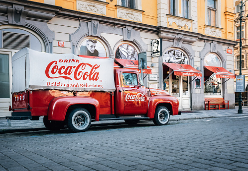Prague, Czech Republic – May 7, 2017: An old renovated 1930 – 1940s  Coca-Cola red delivery pickup truck 1934 Ford parking on the Prague street  in Prague, Czech Republic