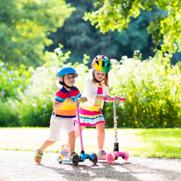 istock Kids riding scooter in summer park. 683047522