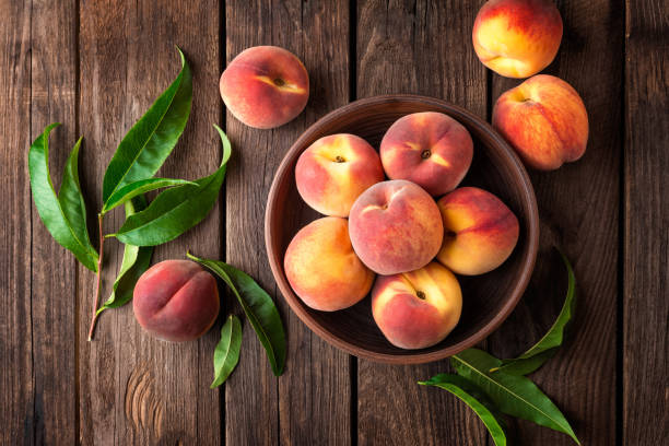 istock Fresh juicy peaches with leaves on dark wooden rustic background 683060176