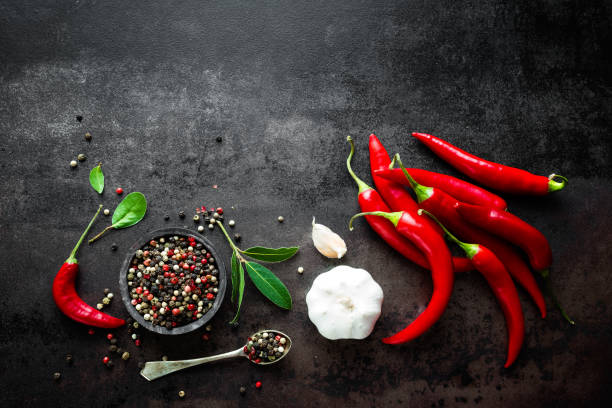 istock Red hot chili pepeprs and peppercorns on black metal background, top view 683060758