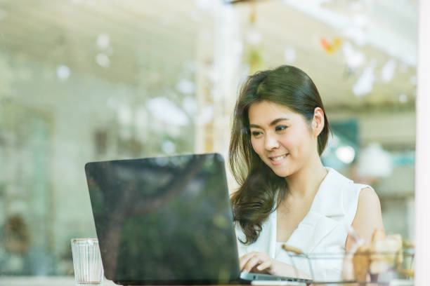 istock happy beautiful young Asian woman smile while working with laptop 683068082