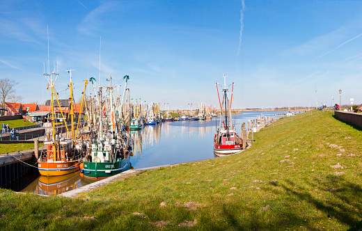 Greetsiel, Germany - March 24, 2017: Tourist harbor of the fishing village Greetsiel, Lower Saxony, East Frisia. The small harbor with its colorful trawlers is a tourist magnet of this North Sea region.