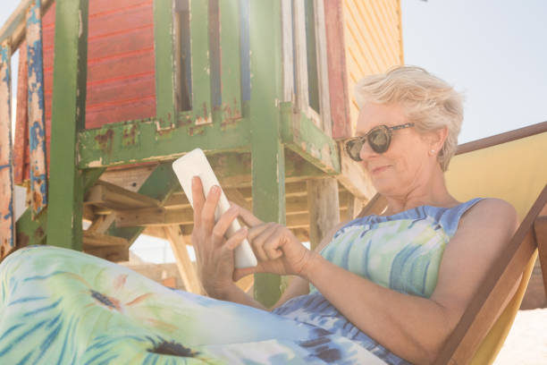 istock Senior woman using mobile phone while sitting on chair 683077558