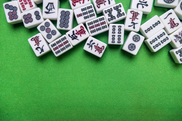 Full of Mahjong tiles game on green background Mahjong also spelled majiang and numerous other variants, it is a tile-based game that platyed  throughout Eastern and South Eastern Asia, it's similar to the western card game rummy. chinese script photos stock pictures, royalty-free photos & images