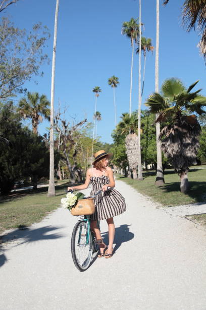 istock Woman riding bicycle in a tropical park. 683084184