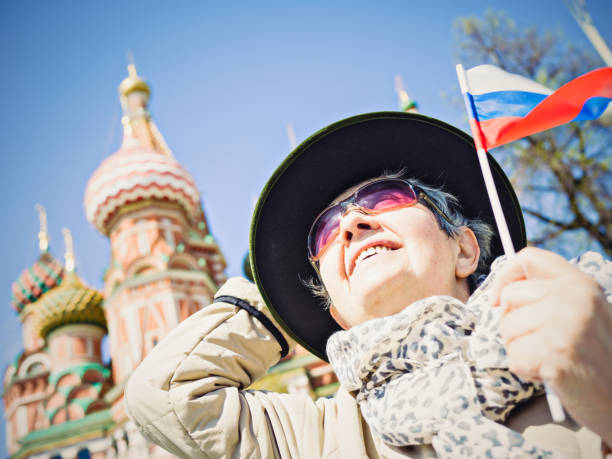 Senior woman with Russian flag at Red Square in Moscow Senior woman with Russian flag at Red Square in Moscow ariel west bank stock pictures, royalty-free photos & images