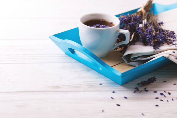 Cup of coffee with lavender flowers on white wooden table. Lifestyle concept. Selective focus