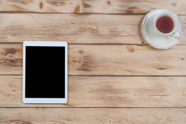 istock Cup of coffee and digital tablet on wooden table. 683149762