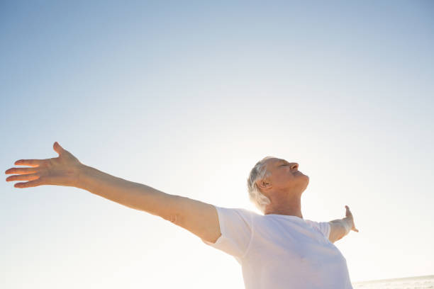 istock Active senior man with arms outstretched standing against clear sky 683155508