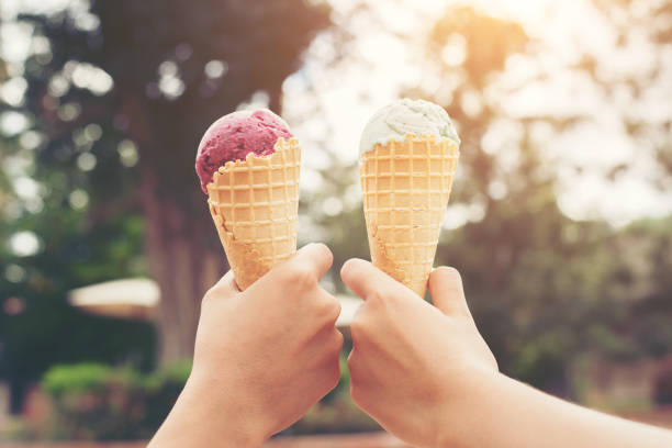 istock Woman's hands holding melting ice cream waffle cone in hands on summer light nature background 683158300
