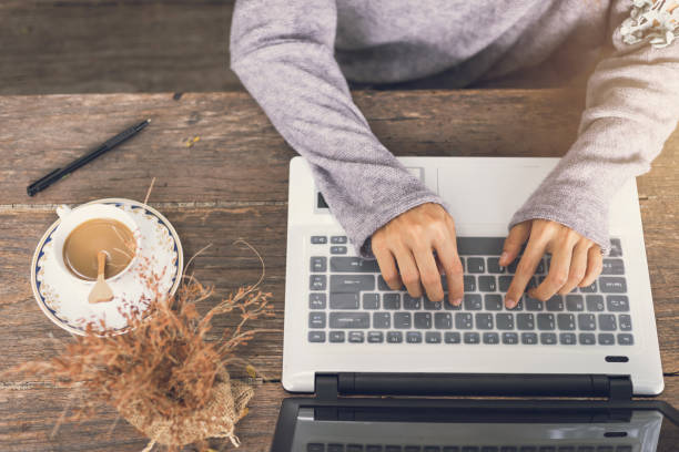 istock Young woman working by using a laptop on wooden table 683169642