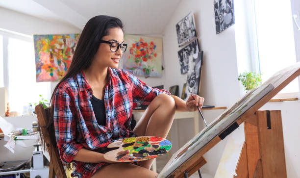 istock Young woman sitting and drawing nature morte in workshop 683172750