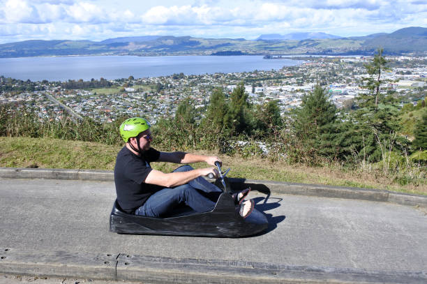 Man ride on Skyline Rotorua Luge Rotorua: Man rides on the Skyline Rotorua Luge. Skyline Luge is a gravity fuelled fun ride. Invented in New Zealand in 1985, and having hosted over 30 million rides worldwide. rotorua luge stock pictures, royalty-free photos & images