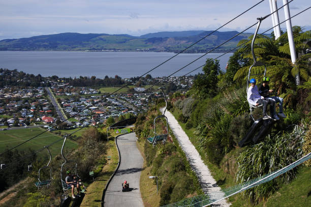 Skyline Rotorua Luge New Zealand Rotorua: People ride on the Skyline Rotorua Luge ride in Rotorua, North Island, New Zealand.. Skyline Luge is a gravity fuelled fun ride. Invented in New Zealand in 1985, and having hosted over 30 million rides worldwide. rotorua luge stock pictures, royalty-free photos & images