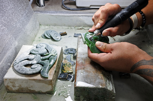 Rotorua: Hands of a Jade ornamental green rock carver at work. New Zealand Jade protected under the Treaty of Waitangi, and the exploitation of it is restricted and closely monitored