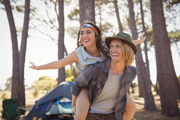 istock Cheerful man piggybacking  woman against trees 683178224