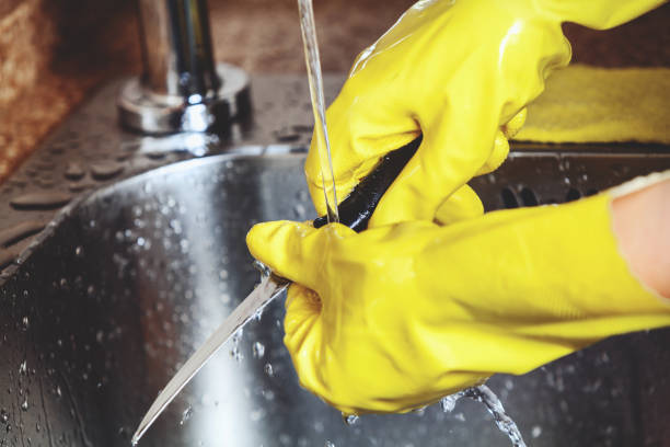 istock Hands in yellow rubber gloves, wash small knife 683188040