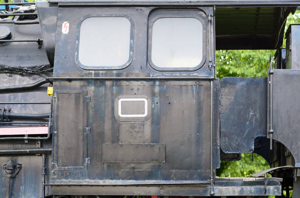 Black cabin of old train locomotive and two windows cropped close-up from outside