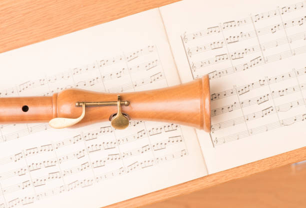 Fermez-vous vers le haut de la flûte à bec en bois et des notes de musique - Photo