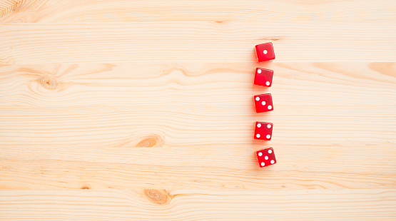 Red dice on wooden background. Concept of gambling, luck and chance.