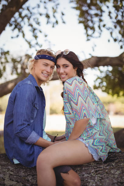 istock Side view portrait of smiling romantic couple sitting on tree trunk 683215492