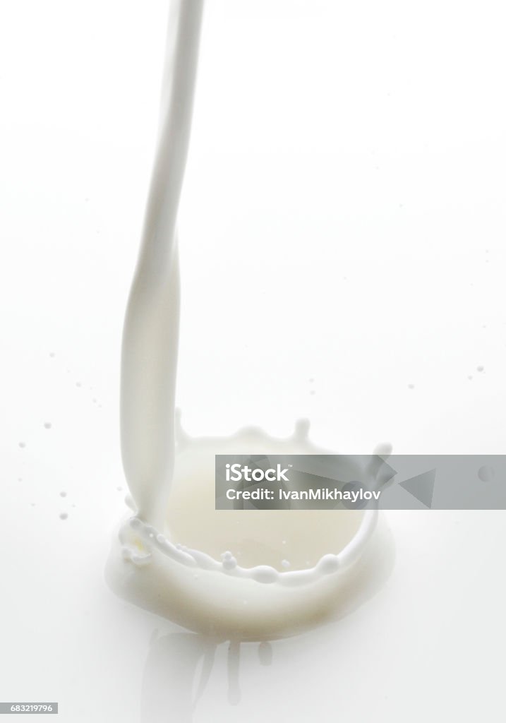 Pouring milk Pouring milk splash on white background macro Falling Stock Photo