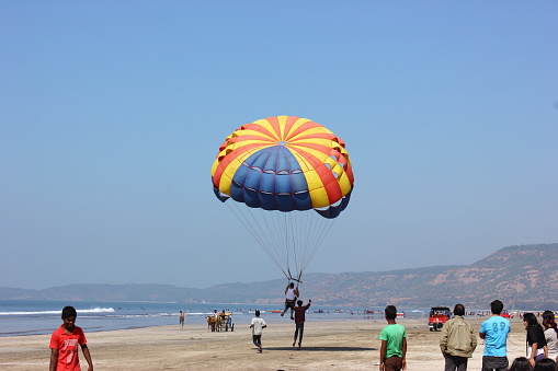 Diveagar, India - February 14, 2017: Tourists are para-sailing in the sunny sea side  on a beach