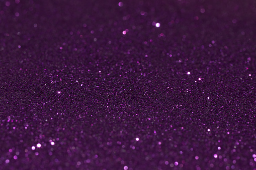 Shiny glitter background in purple color. Christmas decoration.