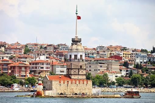 Istanbul, Turkey - Jun 13, 2011: Small boat view with Maiden's Tower in Istanbul, It's one of the symbols of Turkey and there is a part of the Bosphorus at the background with people. Some of people visits the restaurant in tower.