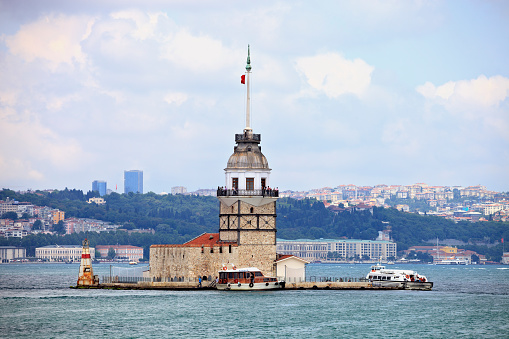 Istanbul, Turkey - Jun 13, 2011: Small boat view with Maiden's Tower in Istanbul, It's one of the symbols of Turkey and there is a part of the Bosphorus at the background with people. Some of people visits the restaurant in tower.