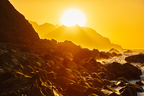 rocks at the edge of the ocean, Benijo beach in the morning,horizon over the mountains.