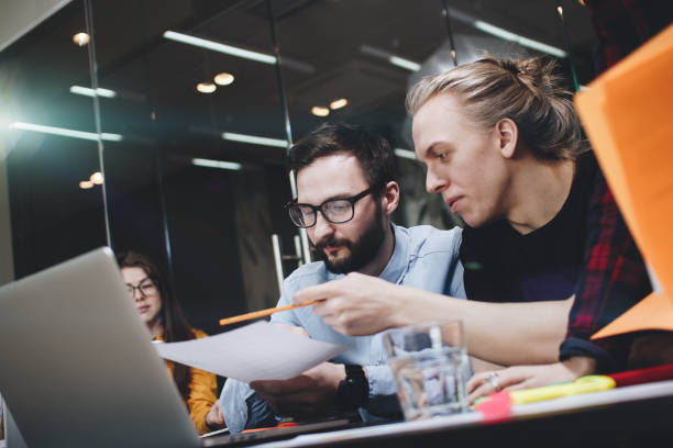 istock Team of young engineering students is working on a new project, discussing diagrams on paper and laptop in a modern loft space 683234368
